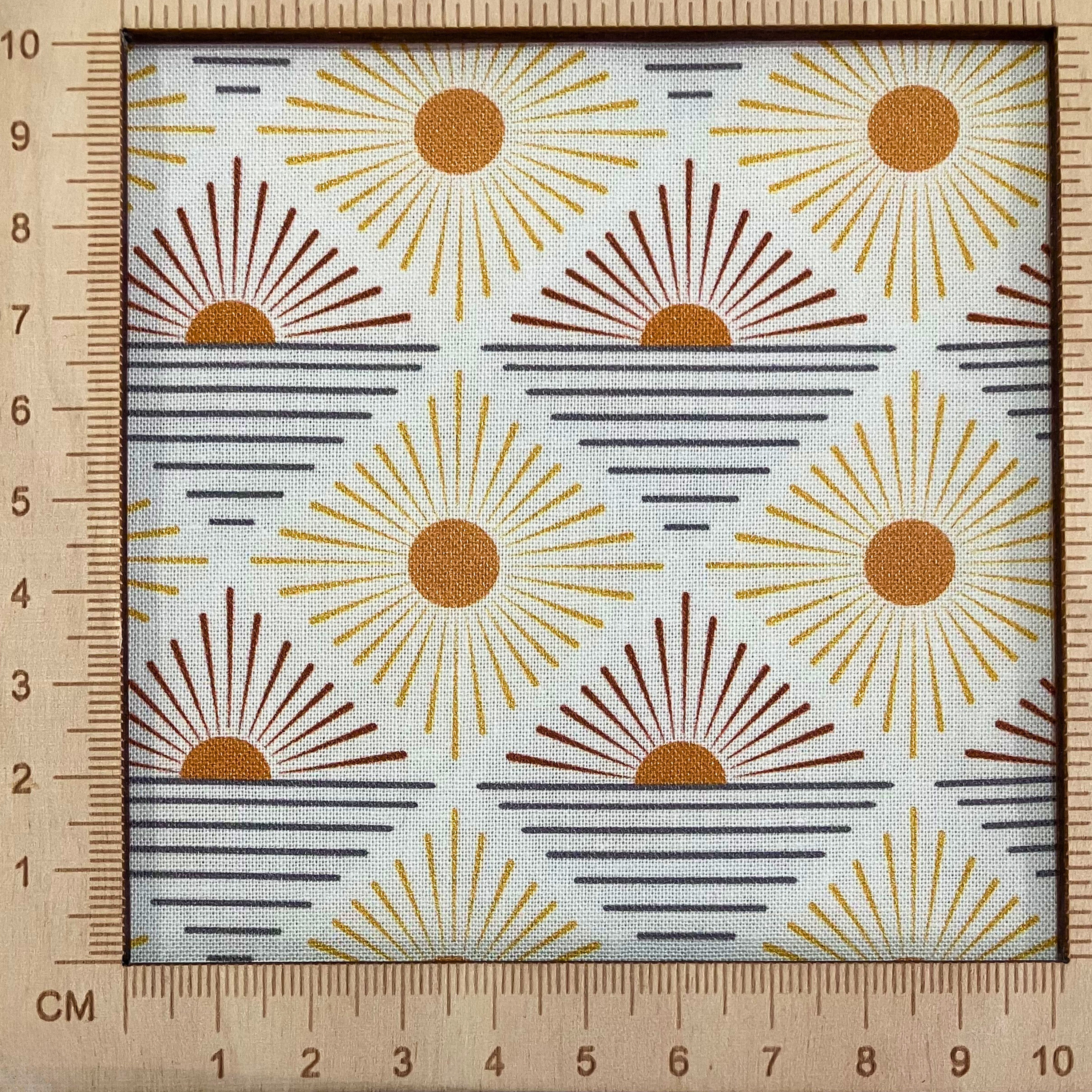 4"x4" scale — 100% cotton quilting fabric — burnt orange sun-like circles in diamond pattern on white. 43/44in width.