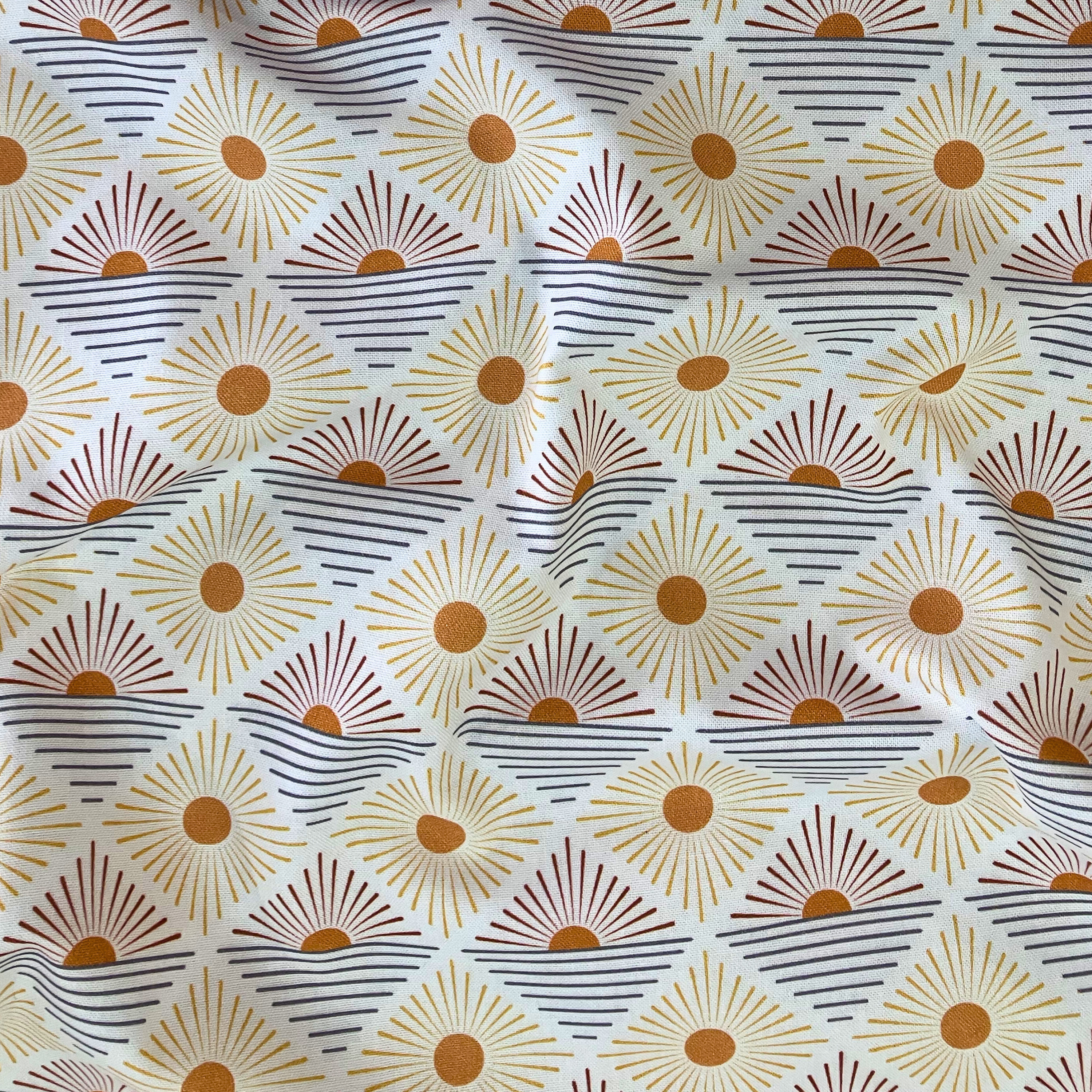100% cotton quilting fabric — burnt orange sun-like circles in diamond pattern on white. 43/44in width.