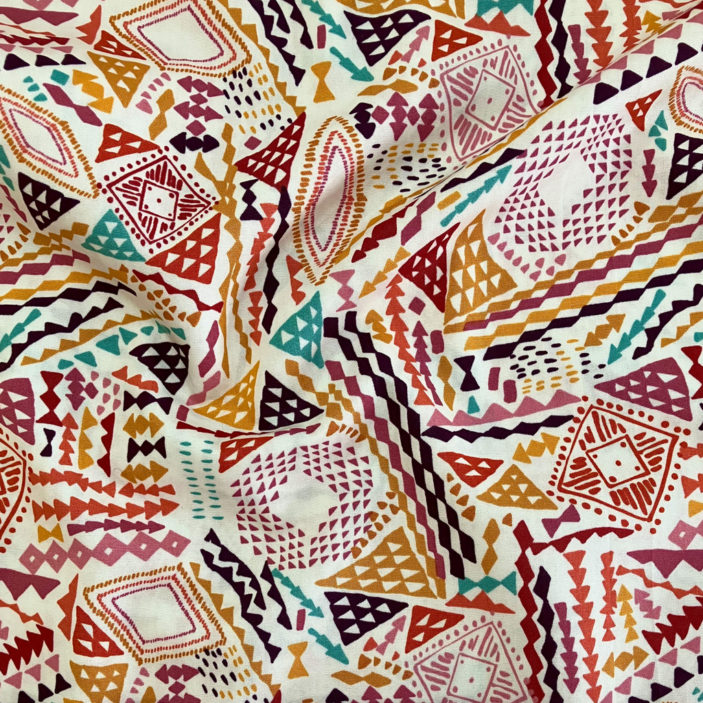 100% cotton quilting fabric — burgundy, redwood, amber & denim triangles on beige. 44in width.