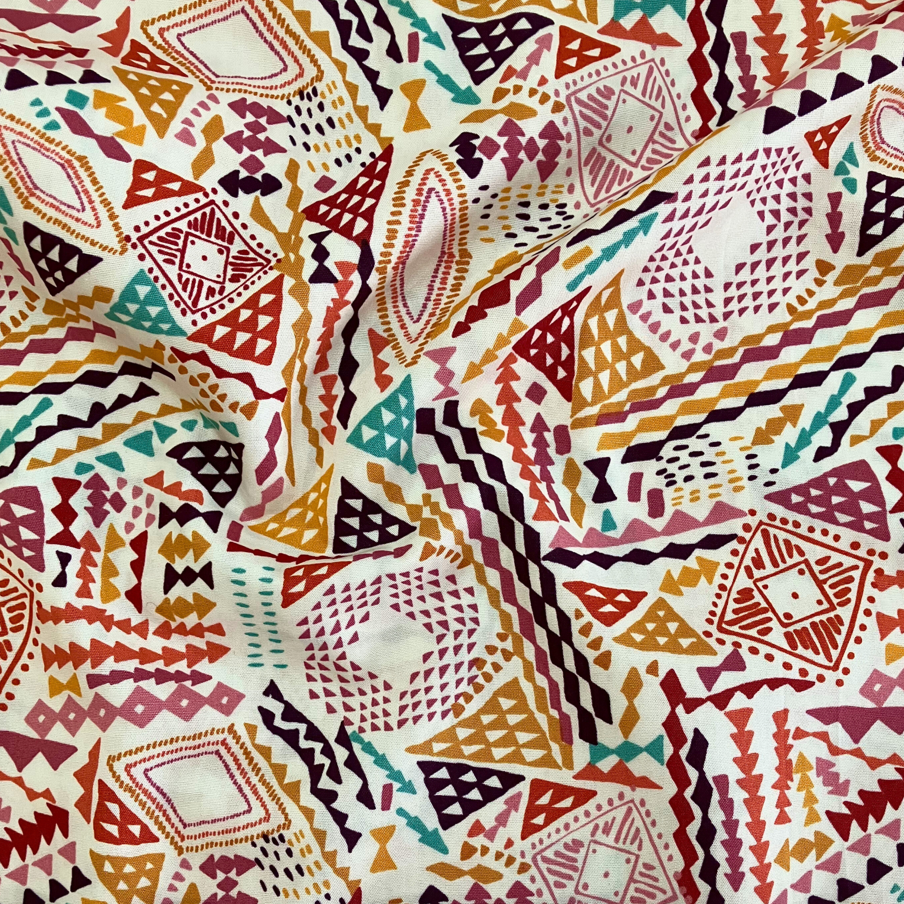 100% cotton quilting fabric — burgundy, redwood, amber & denim triangles on beige. 44in width.