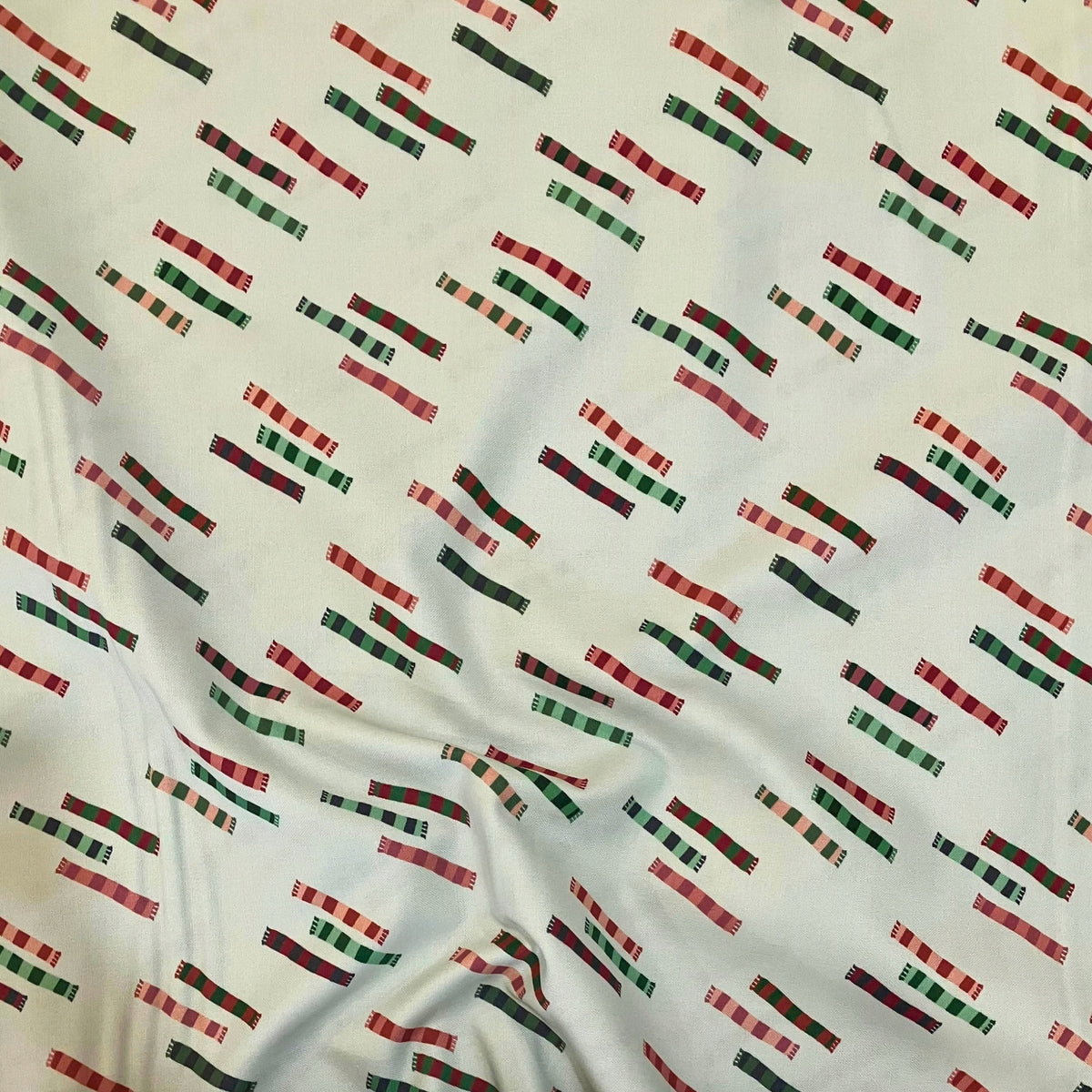 Scarf Closet quilting cotton — tossed striped knitted scarves in red, green, pink and charcoal on a white background. Phoebe Fabrics Wintry collection, 43/44″ wide. Canadian.