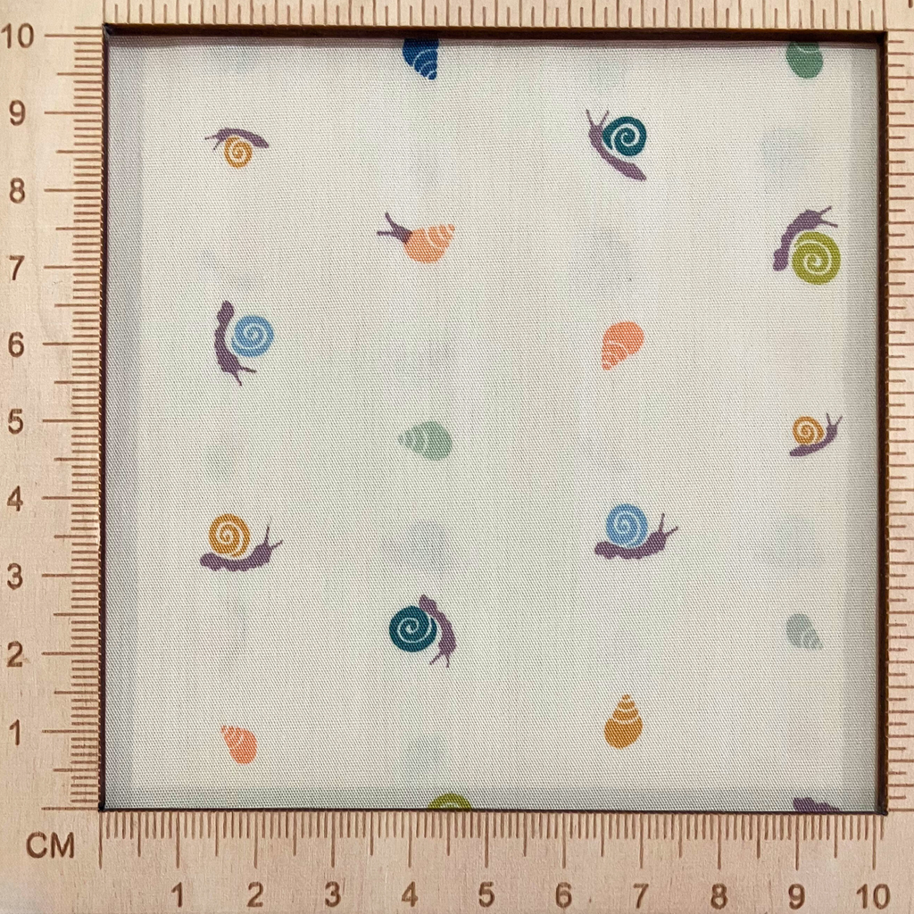 4"x4" scale — 100% cotton quilting fabric — pastel peach, lavender, sky blue & green shells on beige. 43/44in width.