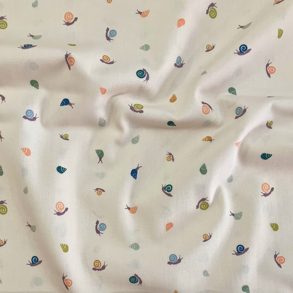 100% cotton quilting fabric — pastel peach, lavender, sky blue & green shells on beige. 43/44in width.