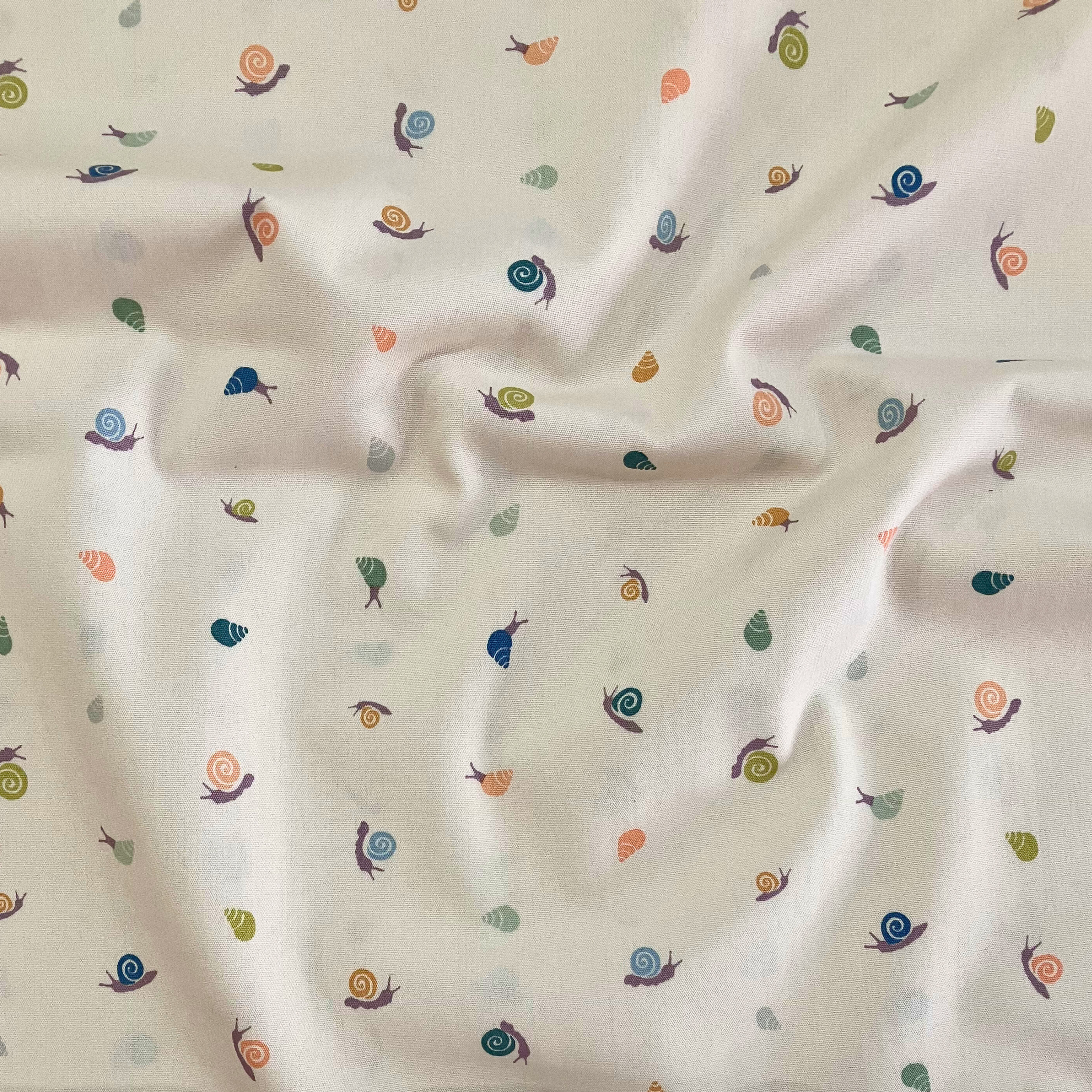 100% cotton quilting fabric — pastel peach, lavender, sky blue & green shells on beige. 43/44in width.