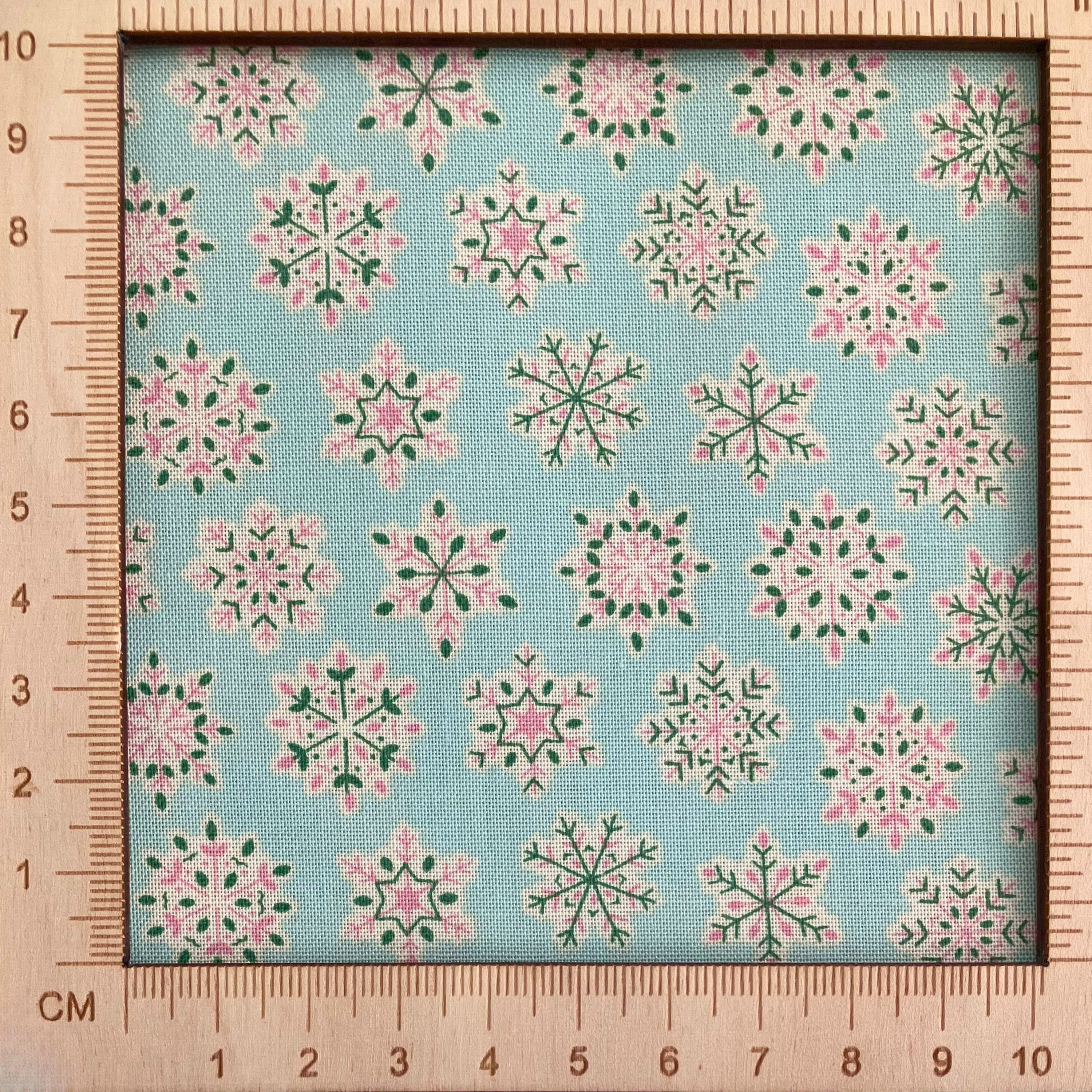 4"x4" scale — Liberty Fabrics Lasenby cotton — Light pink and green geometric snowflake pattern on mint. Festive Greetings collection. 44/45in width.