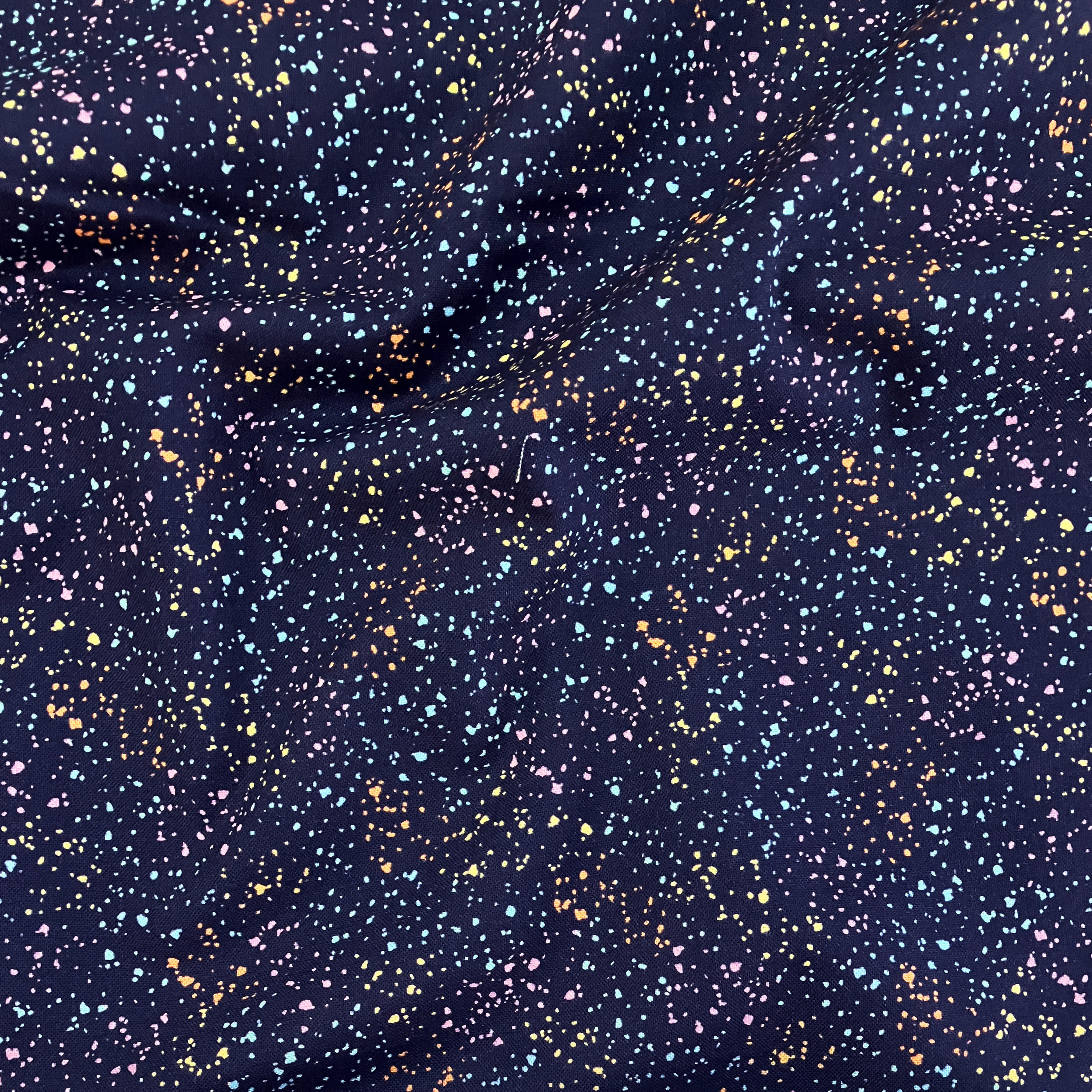100% cotton quilting fabric — multicolour speckles on navy blue. 44/45in width.