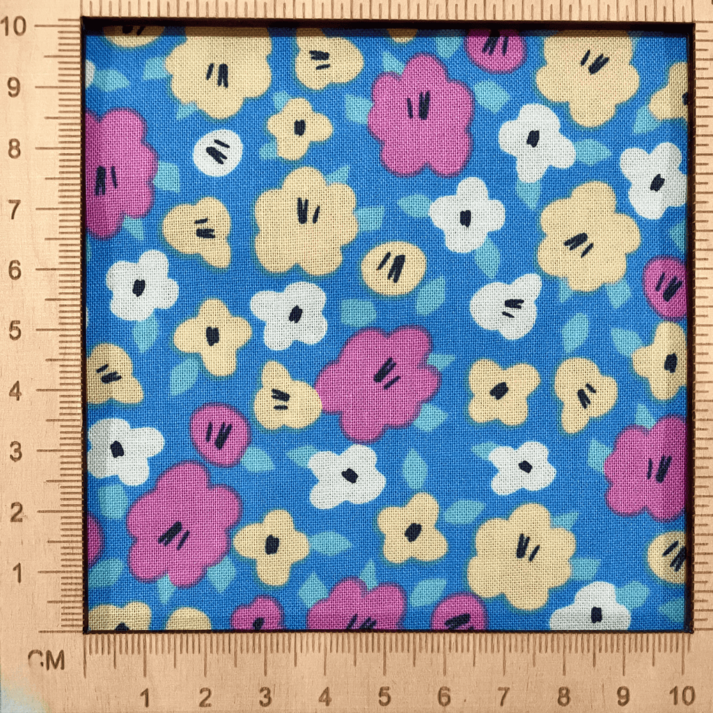 4"x4" scale — 100% cotton quilting fabric — pink, yellow & white flowers on blue. 44/45in width.
