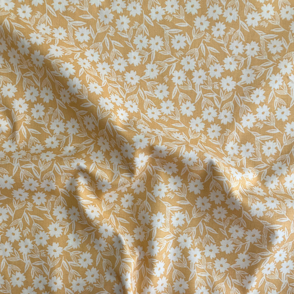 100% cotton quilting fabric — white florals on yellow. 44/45in width.
