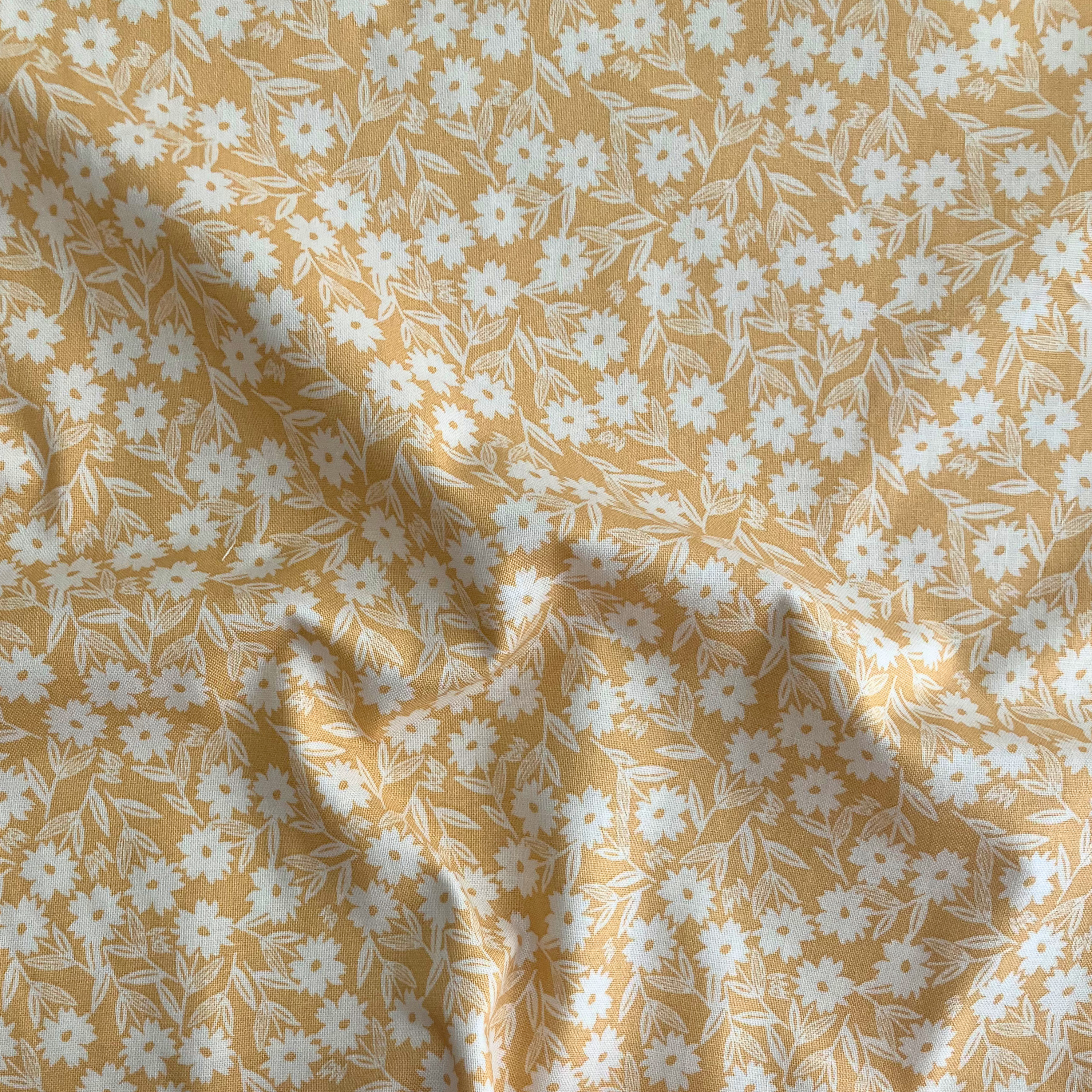100% cotton quilting fabric — white florals on yellow. 44/45in width.