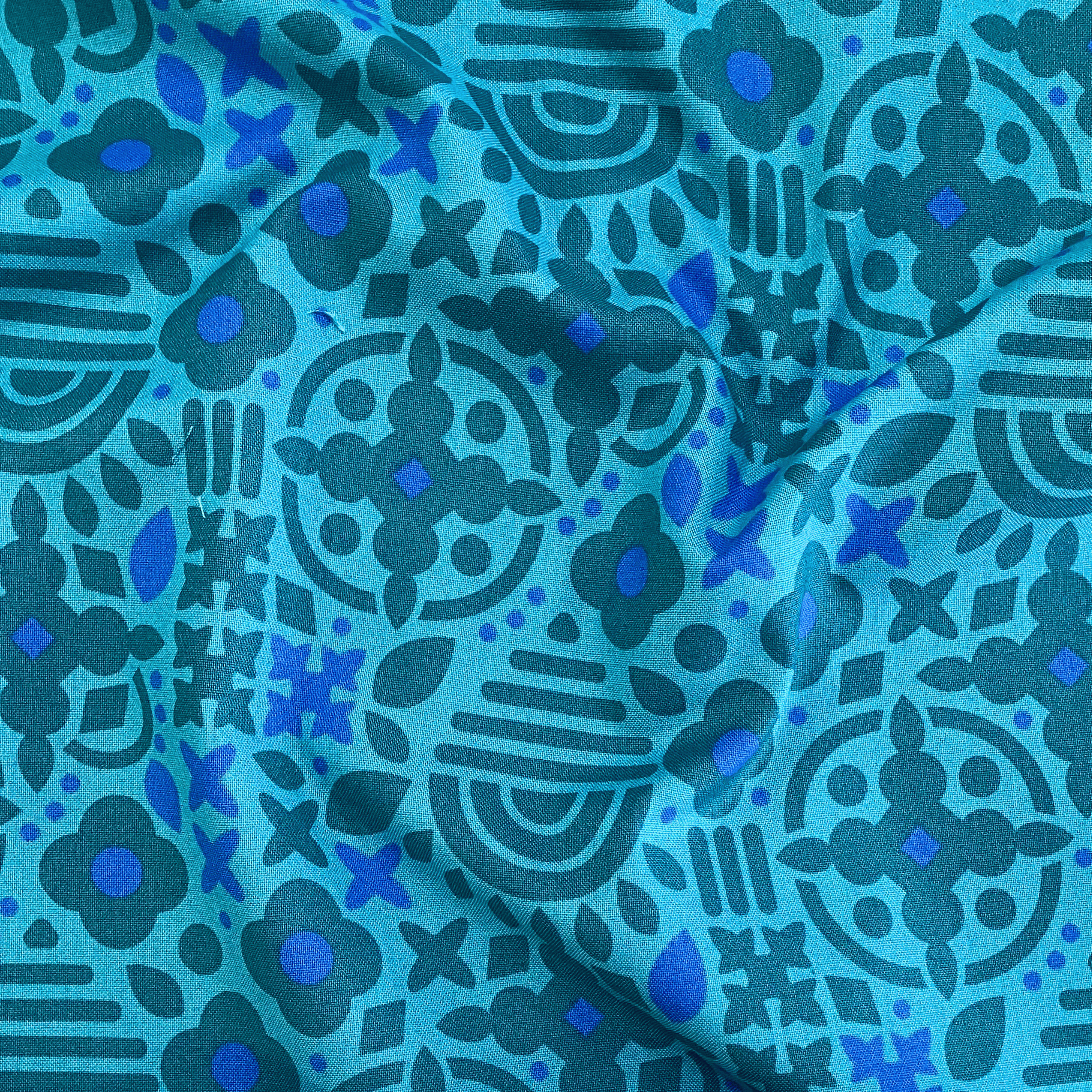 100% cotton quilting fabric — dark turquoise and blue tonal geometric pattern to teal. 44in width.