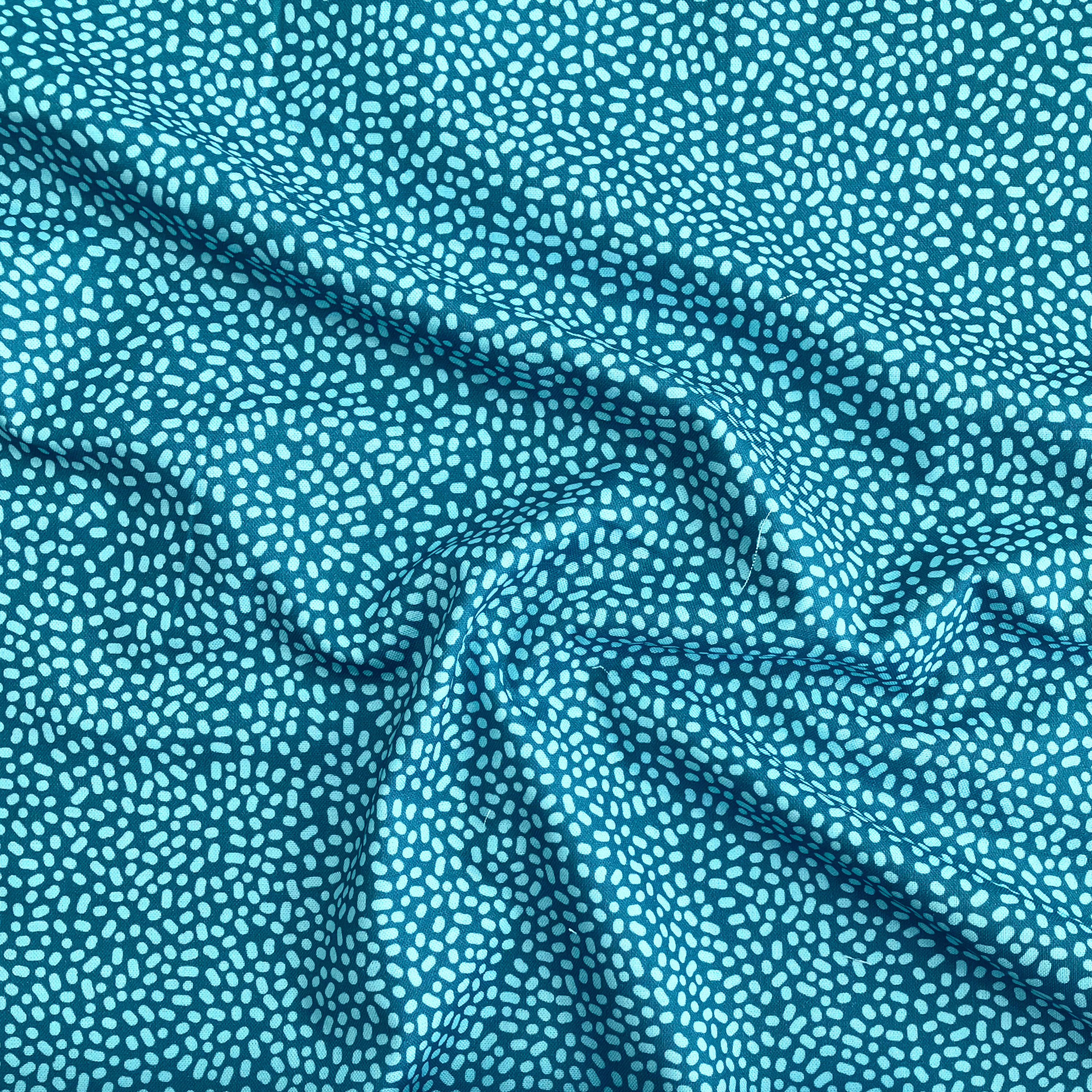 100% cotton quilting fabric — Light green-blue dots on teal. 43/44in width.