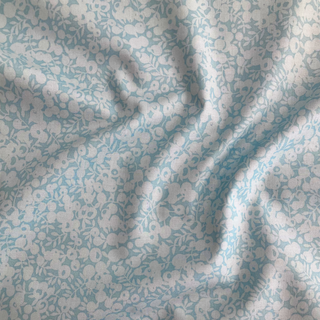 Liberty Fabrics Lasenby cotton — subtle tonal floral shadow pattern on light blue. 44/45in width.