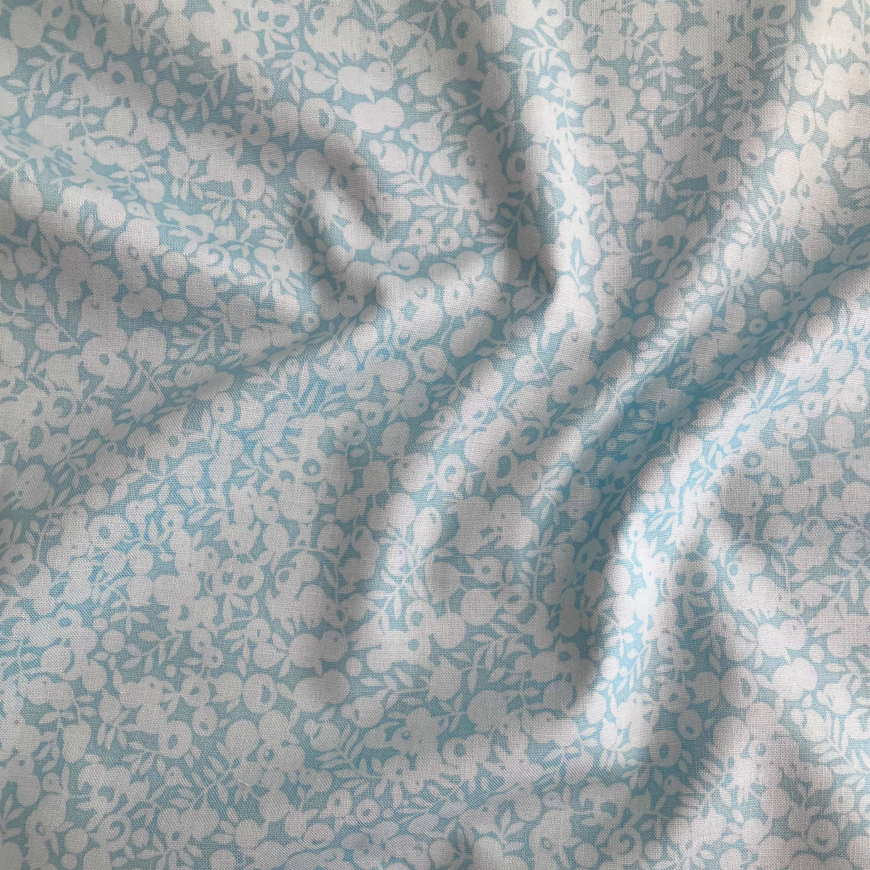 Liberty Fabrics Lasenby cotton — subtle tonal floral shadow pattern on light blue. 44/45in width.