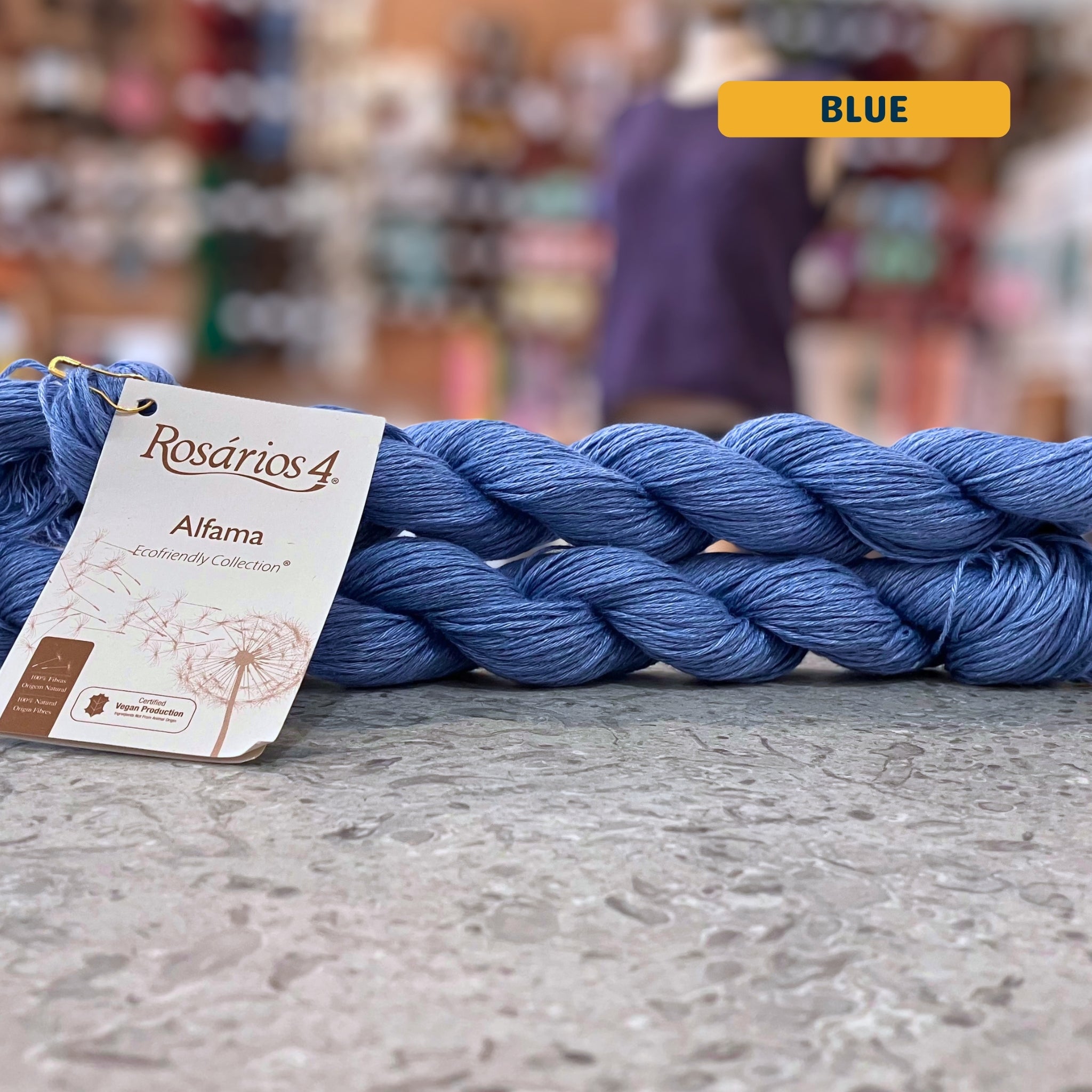 50g blue pure linen dk yarn, 'Rosários4 Alfama Ecofriendly Collection' label visible, craft shop background (blurred)