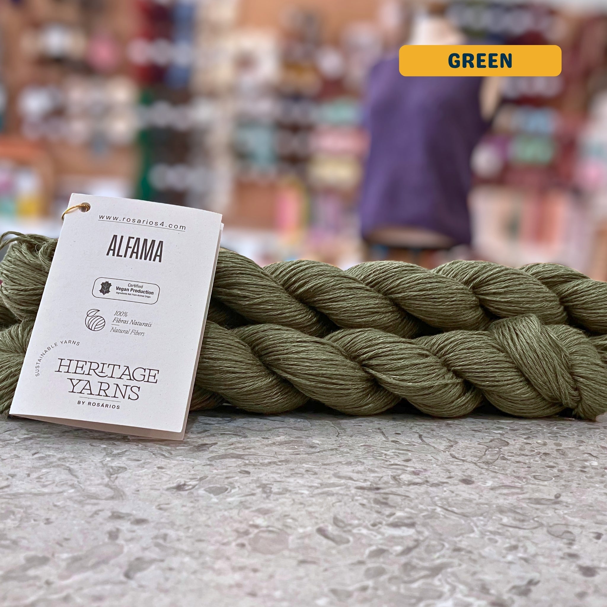 50g dark olive (green) pure linen dk yarn, 'Rosários4 Alfama Ecofriendly Collection' label visible, craft shop background (blurred)