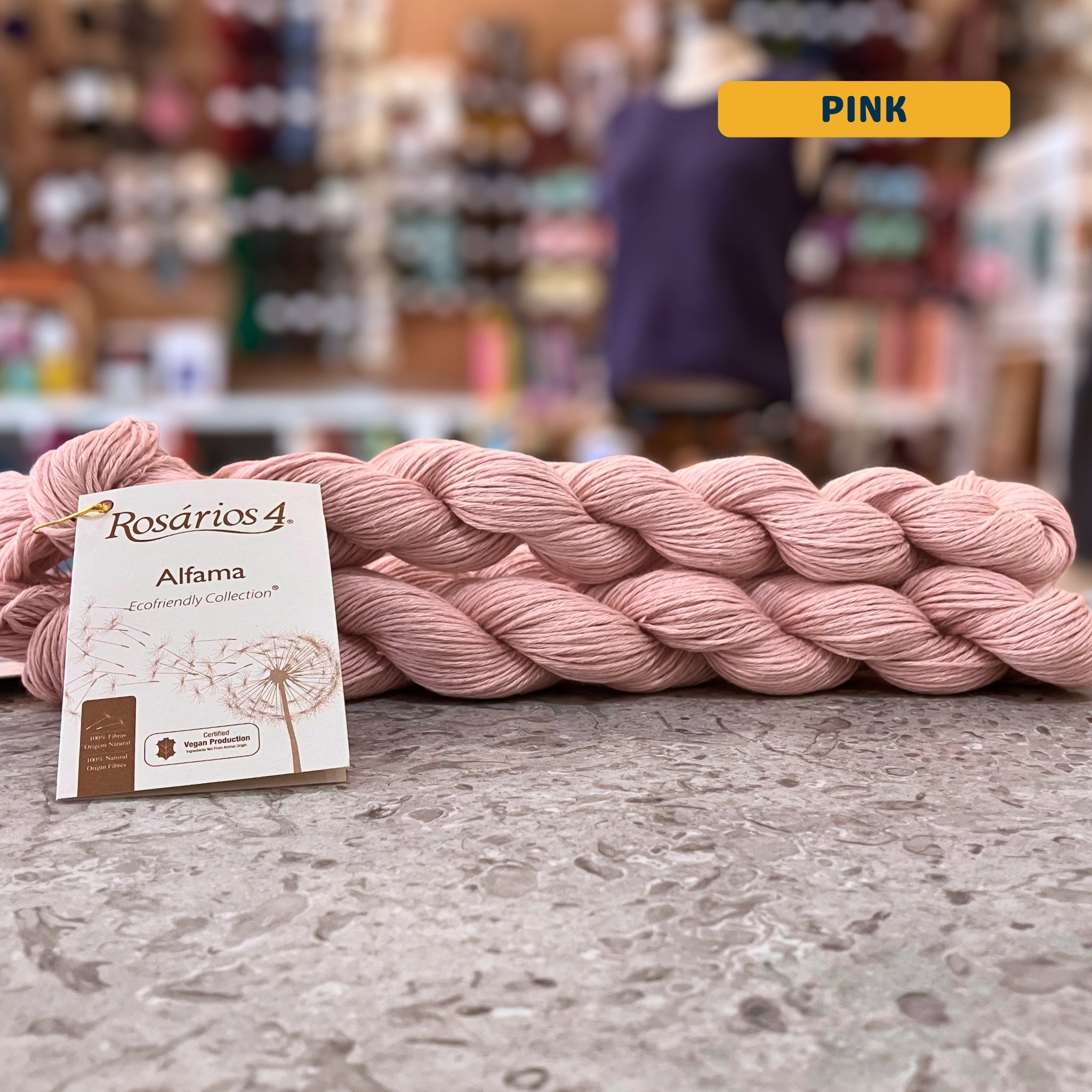 50g light pink pure linen dk yarn, 'Rosários4 Alfama Ecofriendly Collection' label visible, craft shop background (blurred)