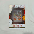 A counted cross stitch pattern card for 'Fall Bell Jar' by Tiny Modernist Cross Stitch, featuring a finished sample of a hedgehog, mushrooms, pumpkins, and more.