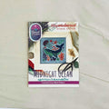A counted cross stitch pattern card for 'Midnight Ocean' by Tiny Modernist Cross Stitch, featuring a finished sample of a whale, jellyfish, & coral.
