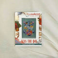 A counted cross stitch pattern card for 'Seas the Day' by Tiny Modernist Cross Stitch, featuring a finished sample of a anchor & sea shells.