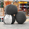 50g grey (c. 201) merino & manchega wool sport yarn, 'Cautiva Wooldreamers  100% Wool' label visible, craft shop background (blurred)