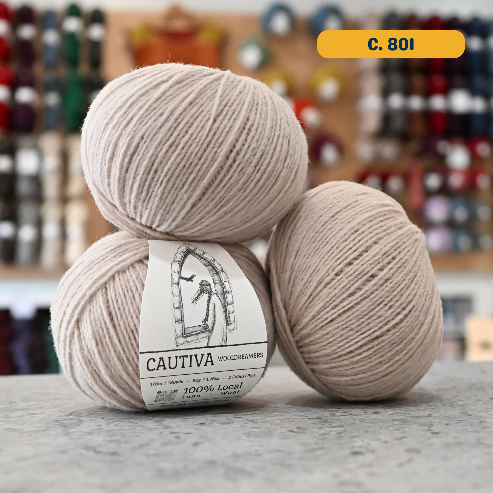 50g cream (c. 801) merino & manchega wool sport yarn, 'Cautiva Wooldreamers  100% Wool' label visible, craft shop background (blurred)
