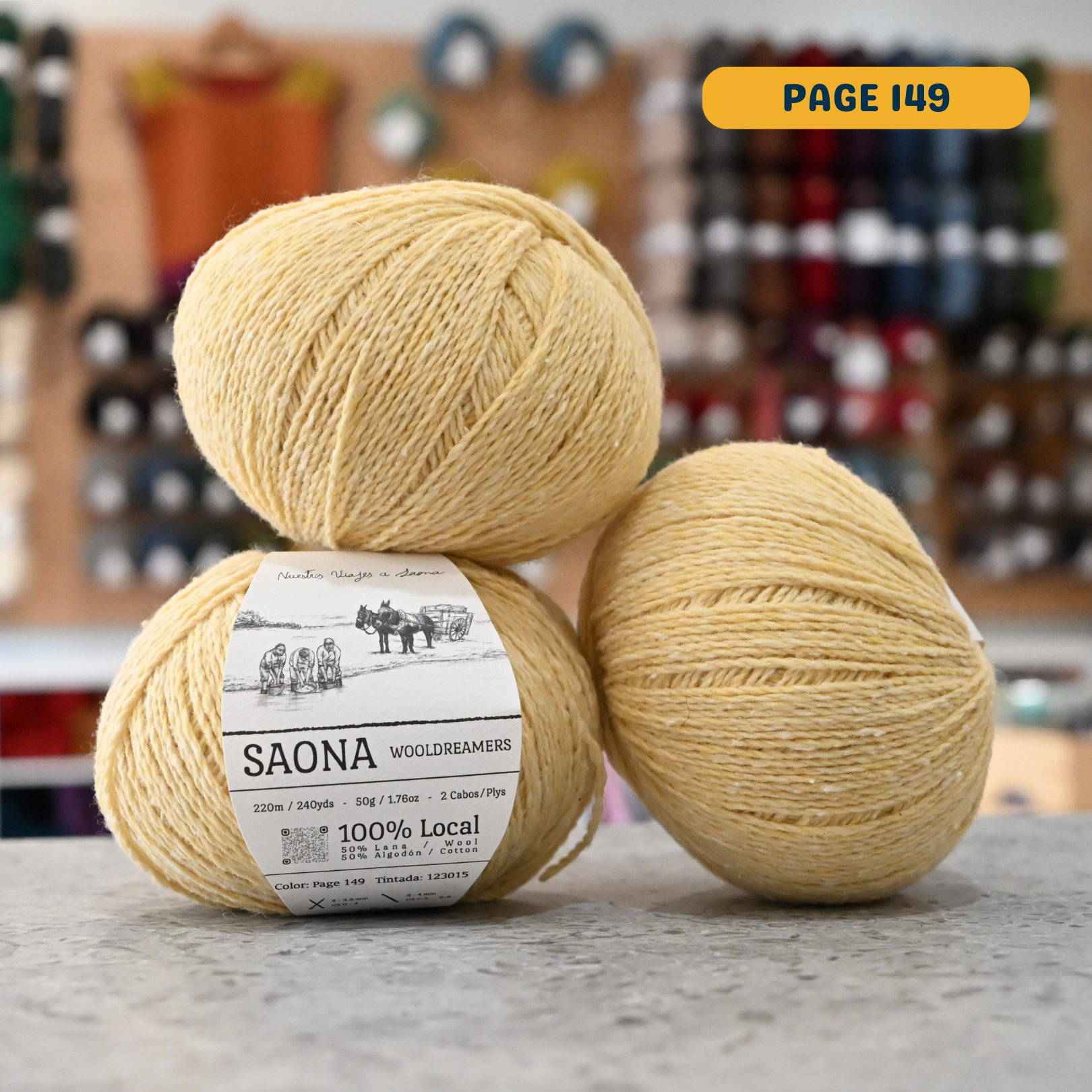 50g light yellow (page 149) wool & cotton fingering yarn, 'Saona Wooldreamers' label visible, craft shop background (blurred)
