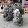100g natural grey undyed Irish wool sport yarn, '100% Irish Wool Yarn Vibes Vale' label visible, craft shop background (blurred)